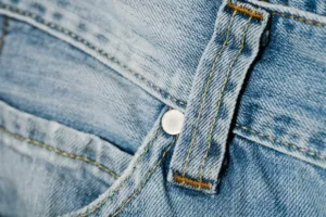 Mais do que aparência: a função invisível dos botões metálicos nos seus jeans