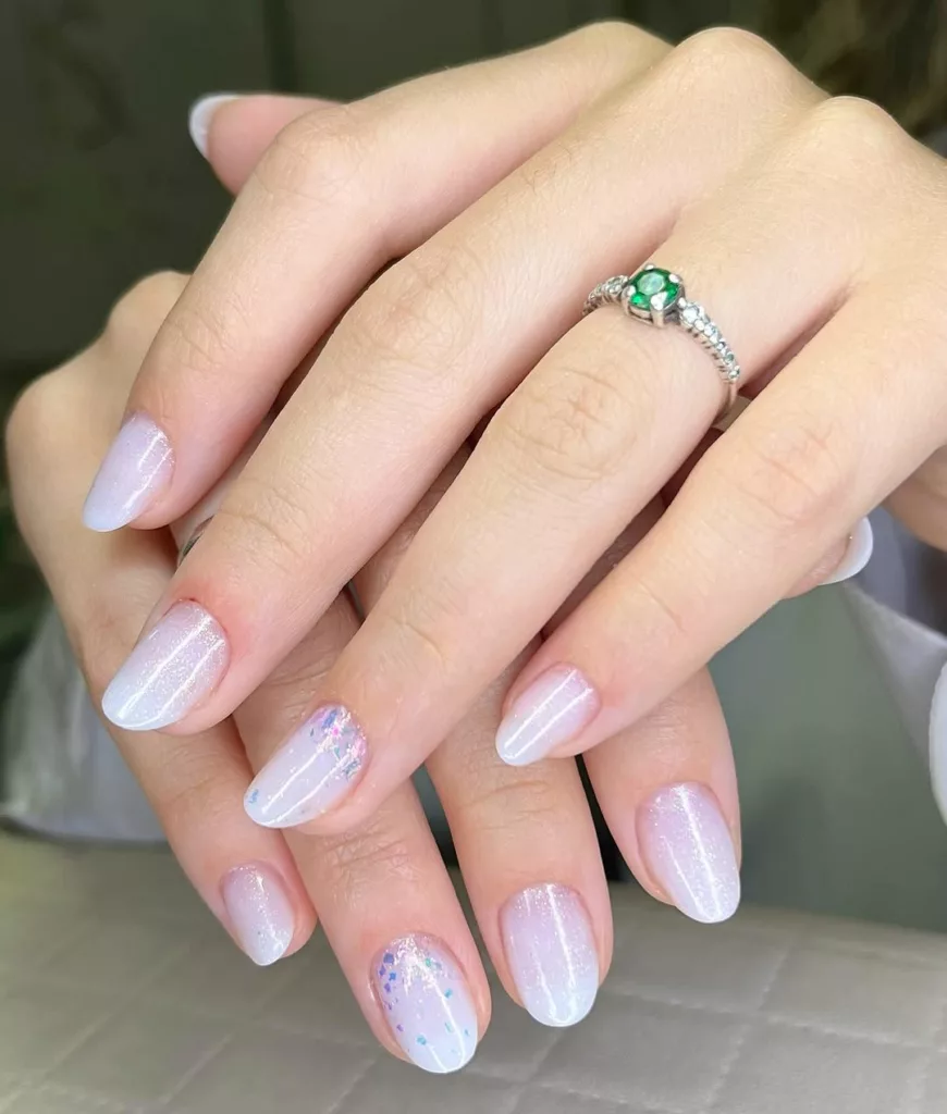 unhas brancas delicadas com glitter dourado