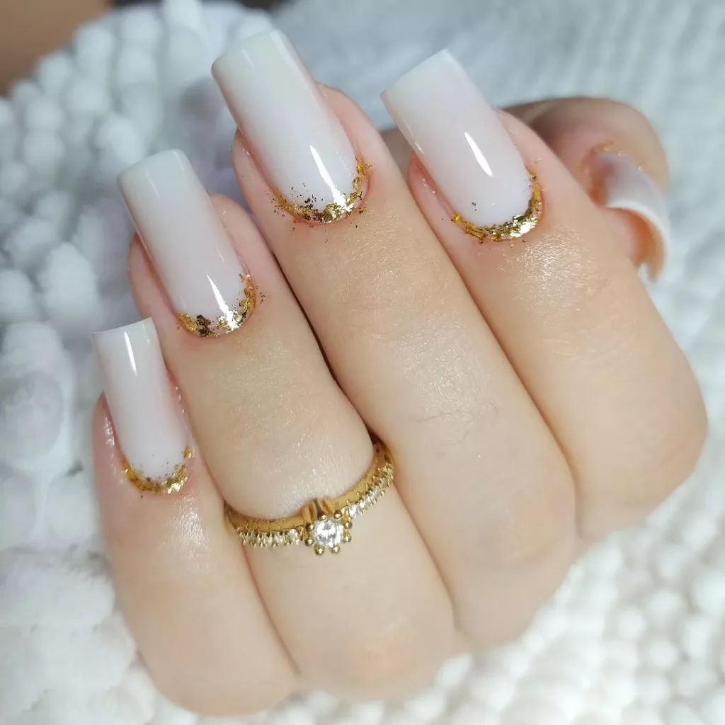 unhas brancas delicadas com base dourada