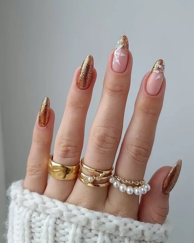 Unhas de Natal com base nude rosada e acabamento dourado com glitter nas pontas, visual sofisticado e elegante.