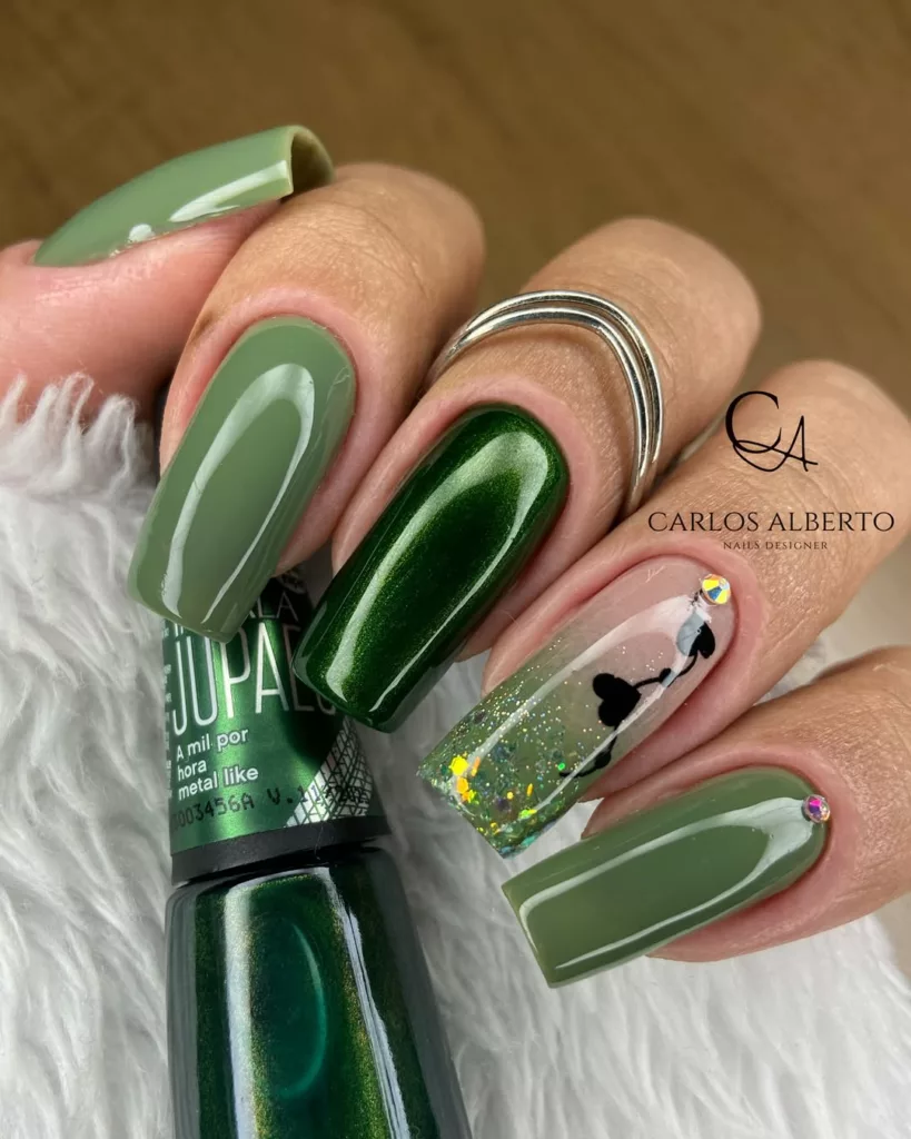 Unhas de Natal em verde escuro com acabamento brilhante e detalhe delicado em uma das unhas.