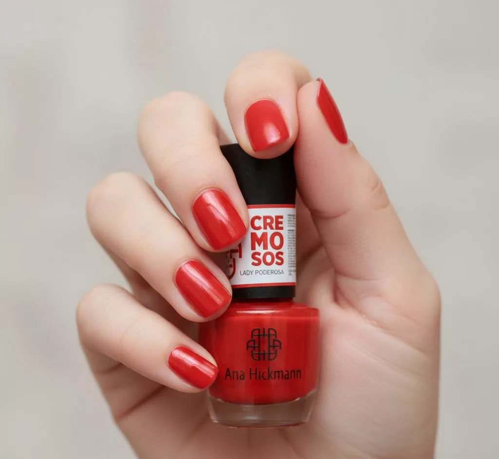 Unhas com esmalte verde cremoso intenso Risqué Ver de Verdade, acabamento brilhante e sofisticado, segurando o frasco do produto, uma opção elegante e atual para unhas natalinas fora do óbvio.
