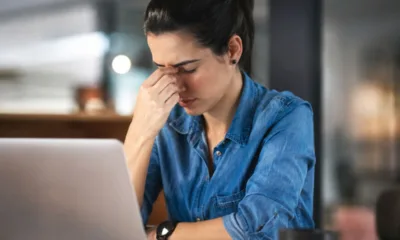 mulher desanimada trsite computador trabalho - Seu corpo grita há anos e você aprendeu a não escutar